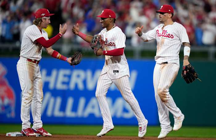 Phillies players Bryson Stott (left), Johan Rojas (center) and Nick Castellanos celebrate a Game 1 win in the NL wild-card series.